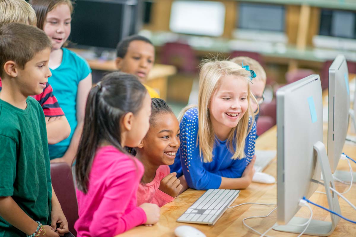 Children gathered around desktop computer